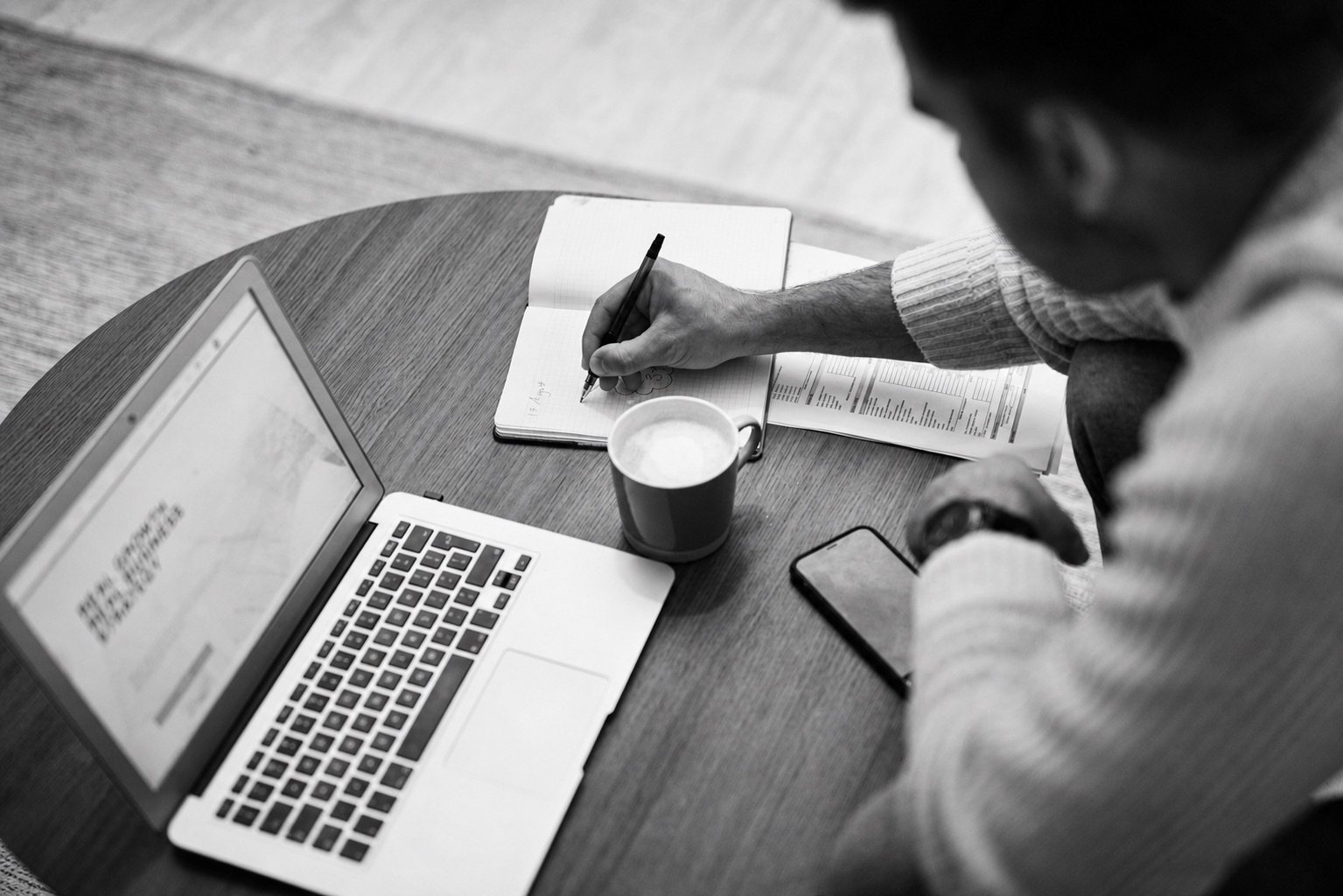 A non-technical founder taking notes while reviewing agency portfolios and Clutch reviews