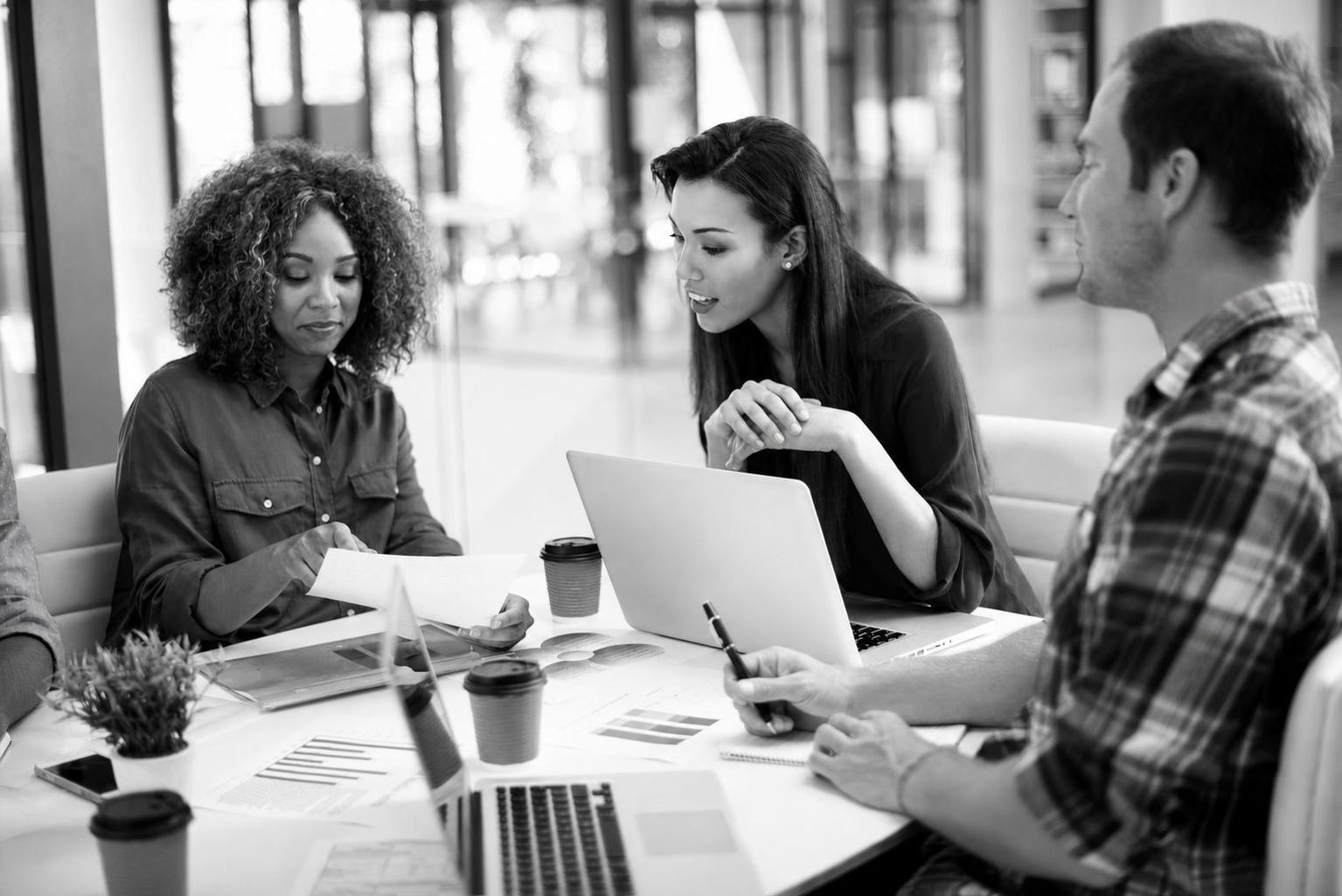 A founder reviewing a product scope document and user flow diagrams with a development team