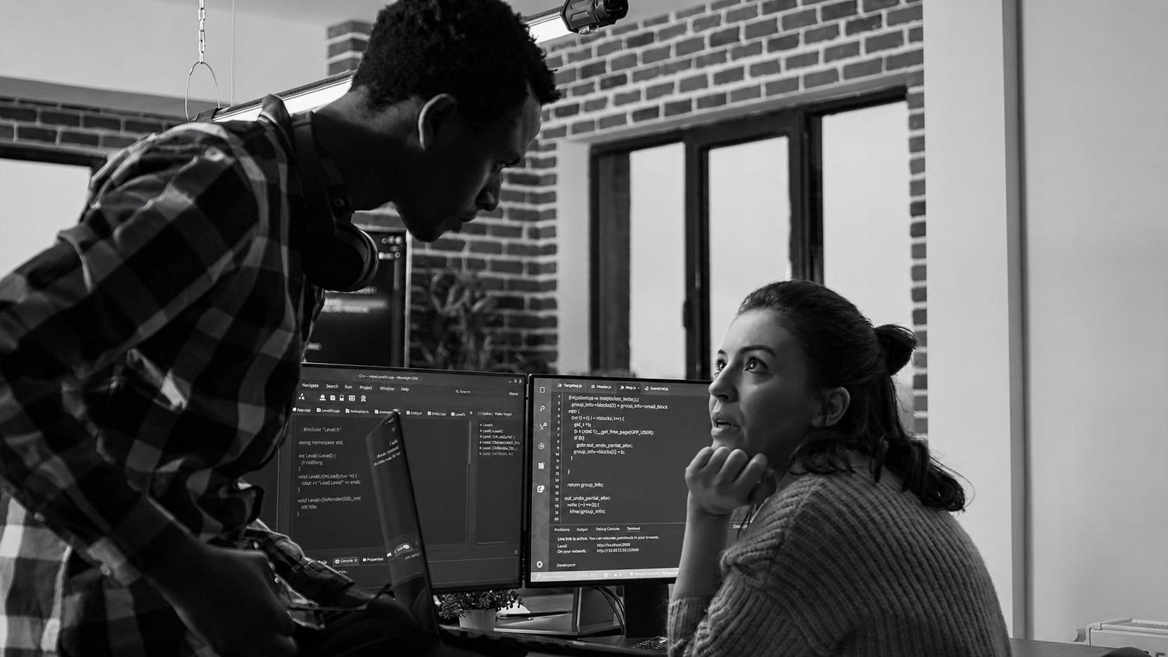 Two developers reviewing source code together, planning a migration
