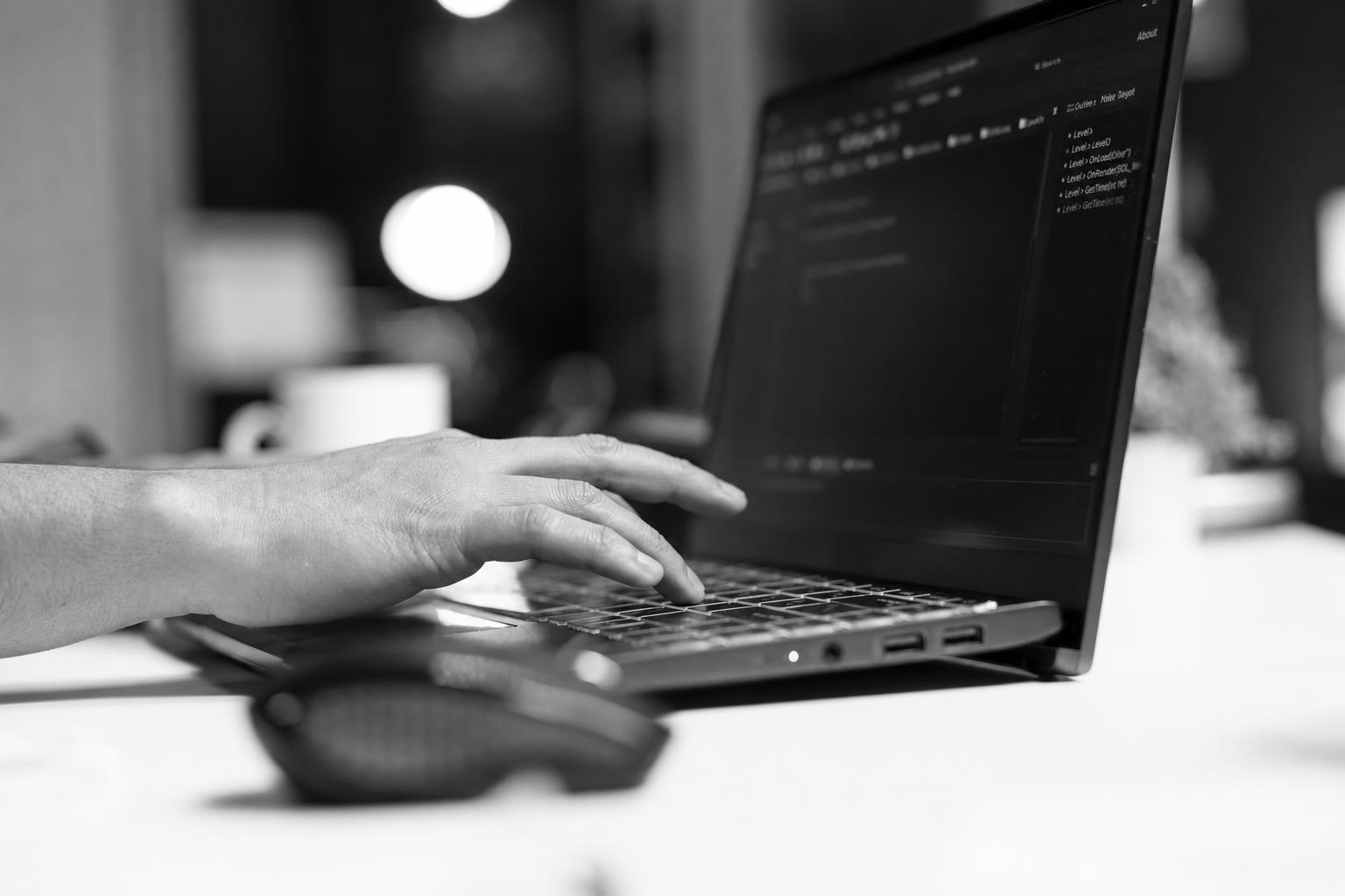 Developer implementing authentication and billing logic on a laptop