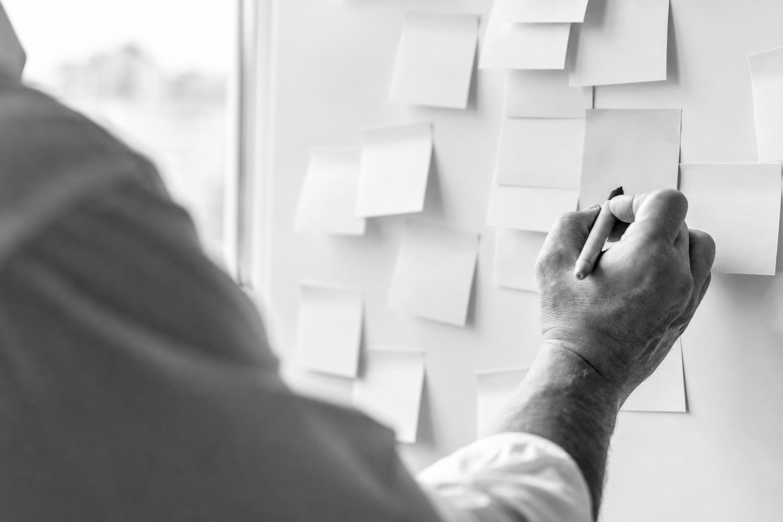 Hand sorting feature ideas on sticky notes down to the essentials