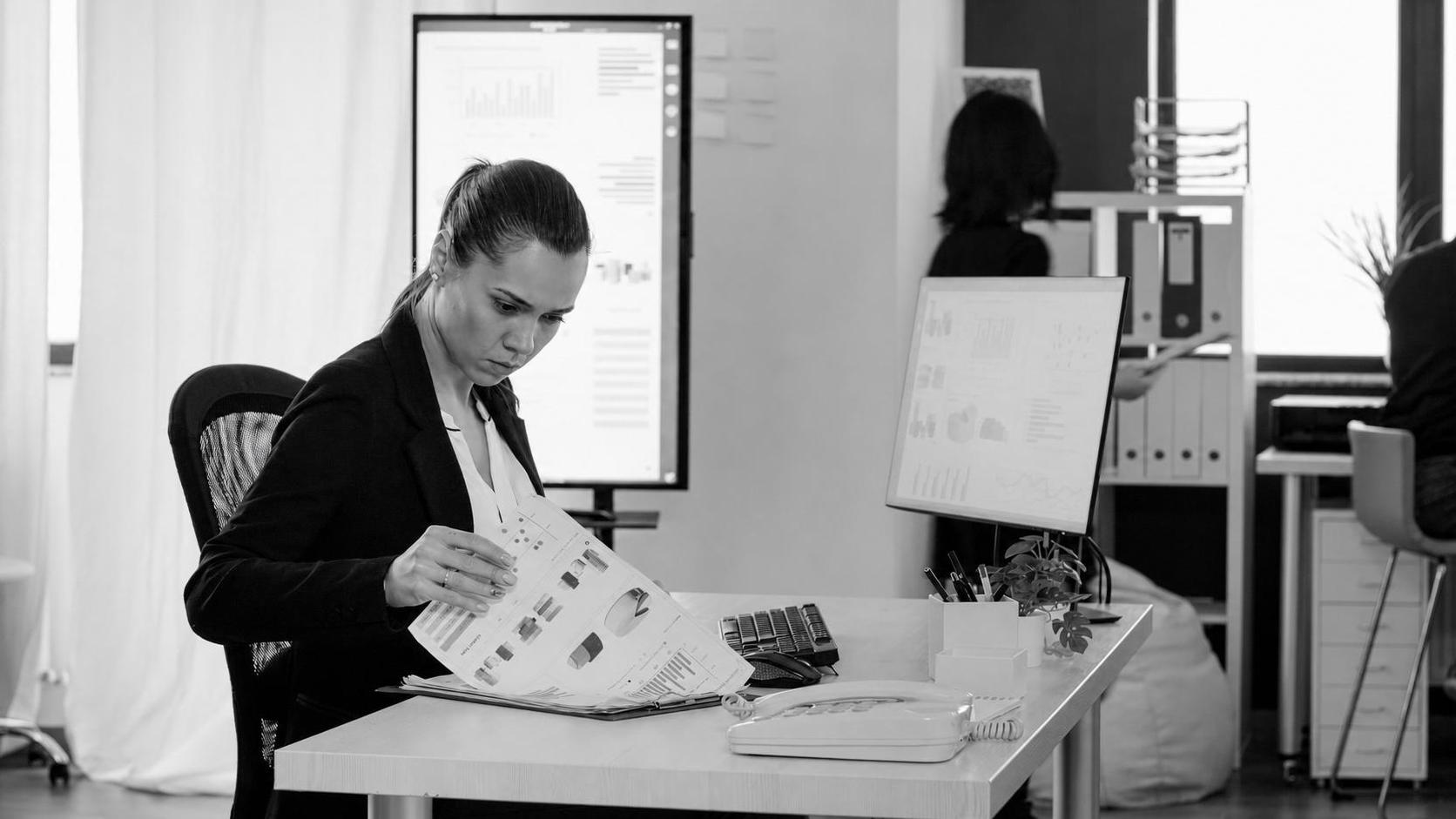 Business analyst reviewing cost and timeline planning charts in an office